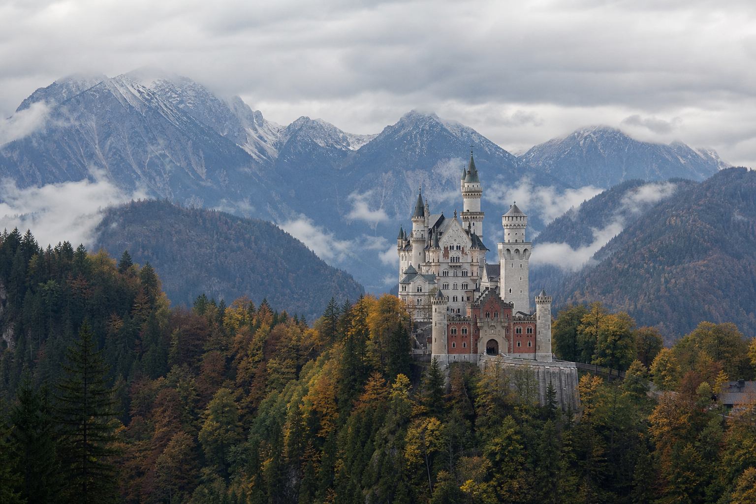 Historisches Schloss über bewaldeter Hügellandschaft